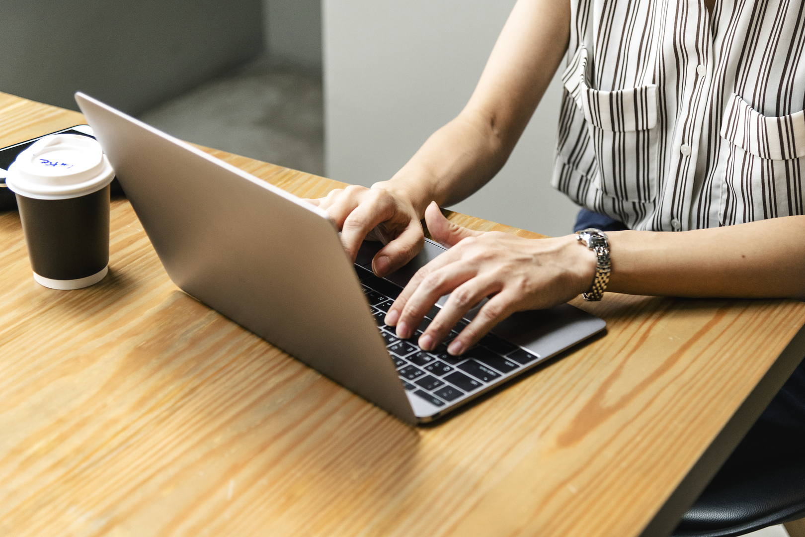 Woman's hands writing on a laptop
